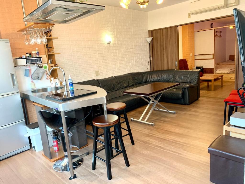 横滨YokohamaKannai HouseBar的厨房以及带沙发和桌子的客厅。