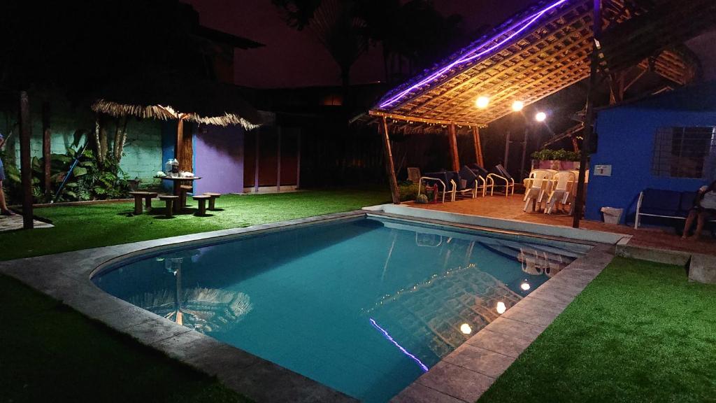 通苏帕La casa de naty by Ecuapolsky的夜间在房子前面的游泳池