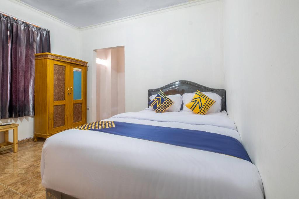 PundongOYO Life 2412 Mandala Residence的一间卧室配有黄色和蓝色枕头的床