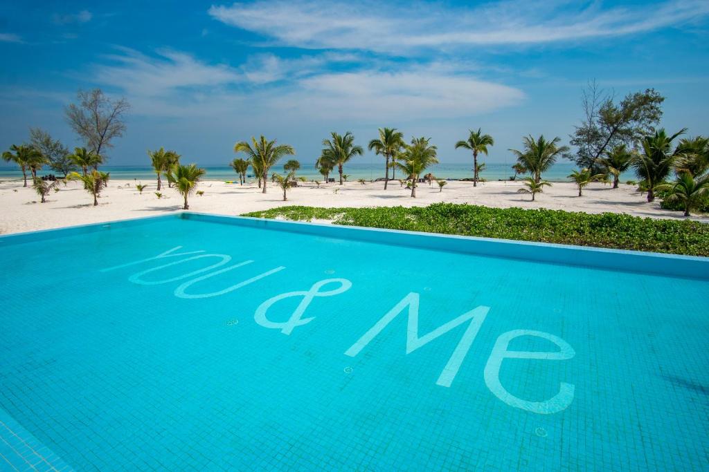 瓜隆岛You&Me Resort的蓝色的游泳池,海滩背景