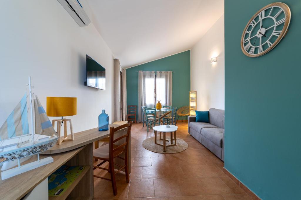 伯吉维奇Rif Holiday Home Stagnone Marsala的客厅配有沙发和墙上的时钟