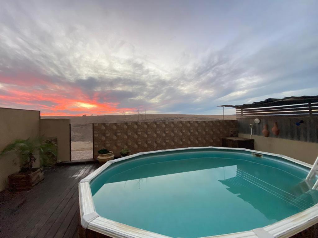 阿拉德Desert Pearl Arad的一座享有日落美景的建筑的顶部游泳池