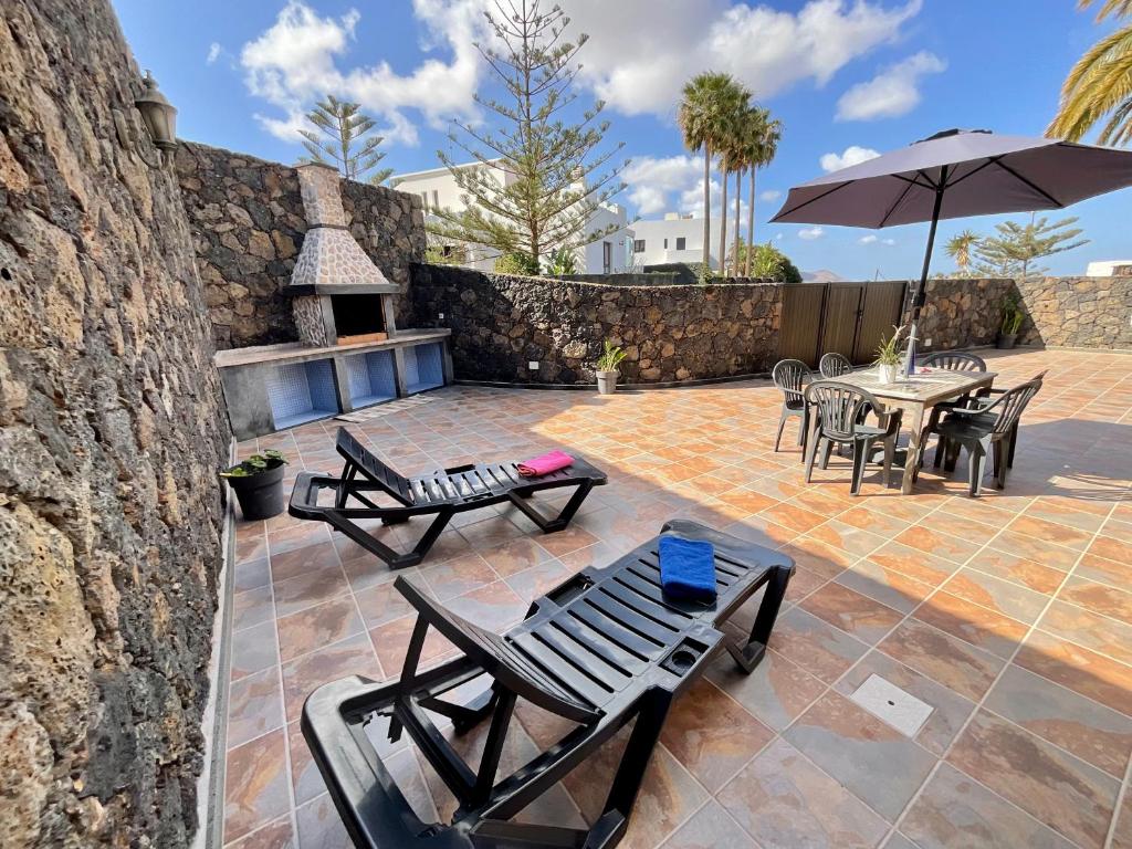 特吉塞Apartamento Catayfa的庭院配有桌椅和遮阳伞。