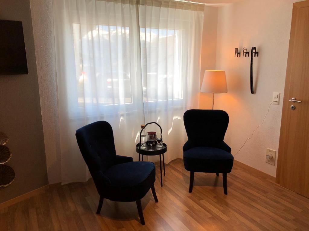 特里森贝格Wonderful & Private Room with en-suite bathroom的一间设有两把椅子、一张桌子和一盏灯的房间