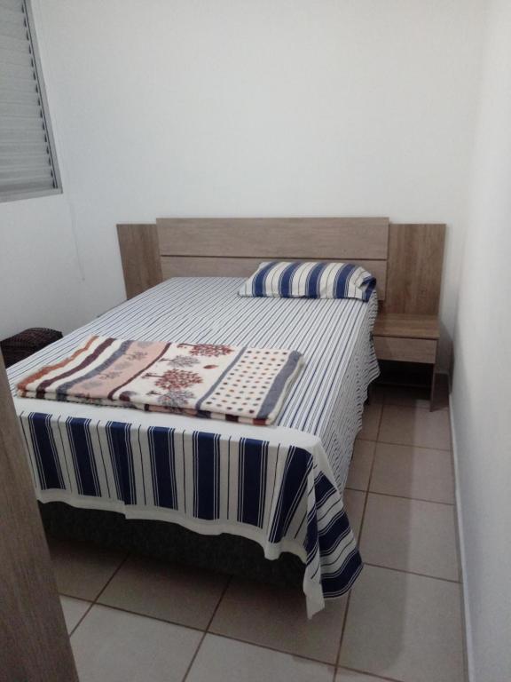 弗朗卡Apartamento proximo ao shopping Franca的一间卧室配有一张床,床上有条纹毯子
