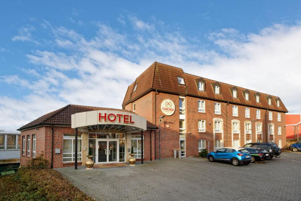 赖讷Cascada Central Hotel Rheine的前面有停车场的酒店