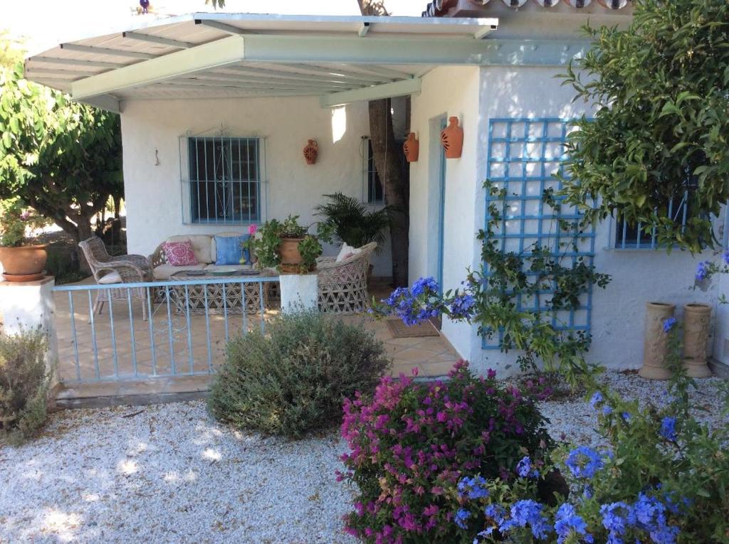 EsteponaMolino Cottage的一座白色的小房子,有门和一些花