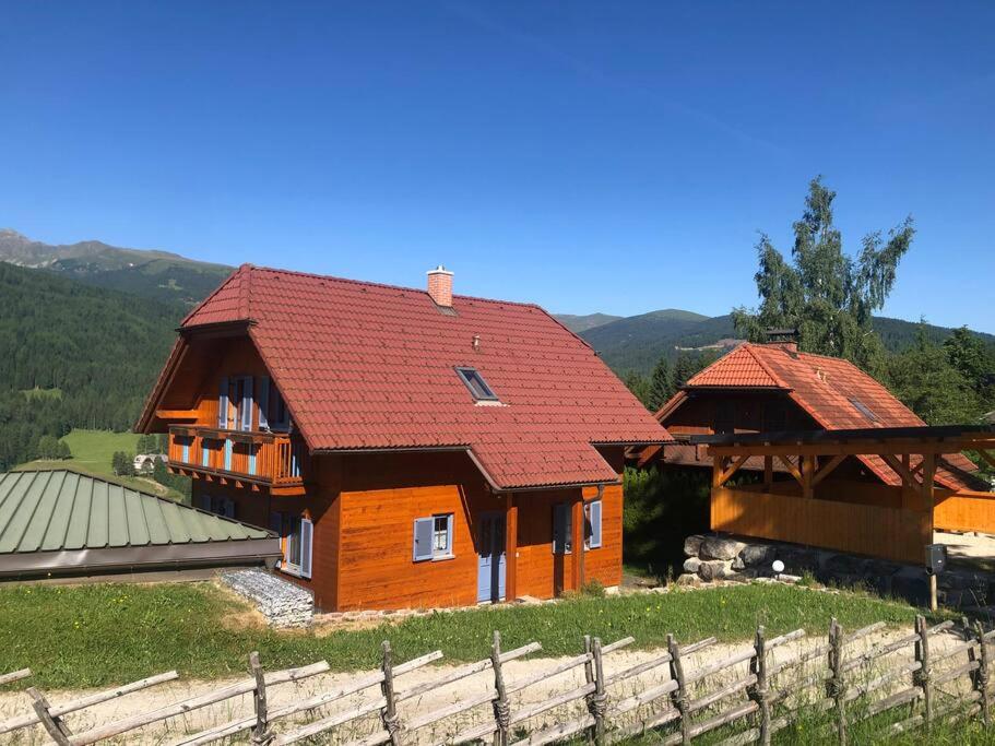 ObdachSt Wolfgang-Kienberg - Ruhe und Entspannung mit bester Aussicht的围栏旁有红色屋顶的房子