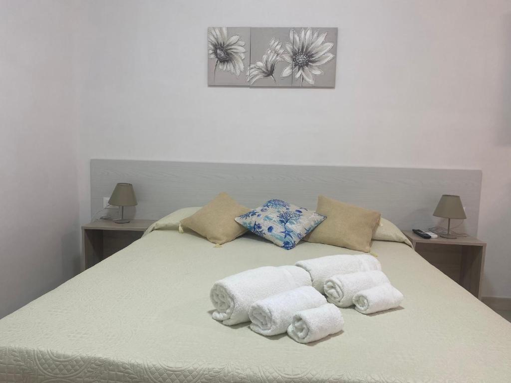 兰佩杜萨Villa Misangi的一张带毛巾和枕头的床