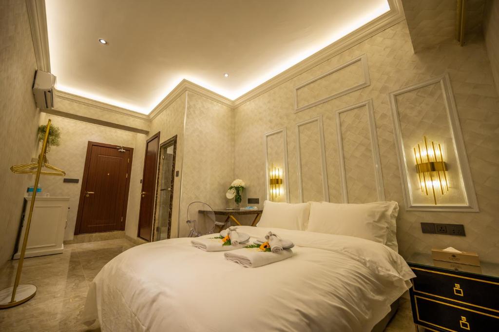 哥打京那巴鲁ACJ Residence @ Beside Cititel Hotel的卧室配有一张带2条毛巾的大型白色床