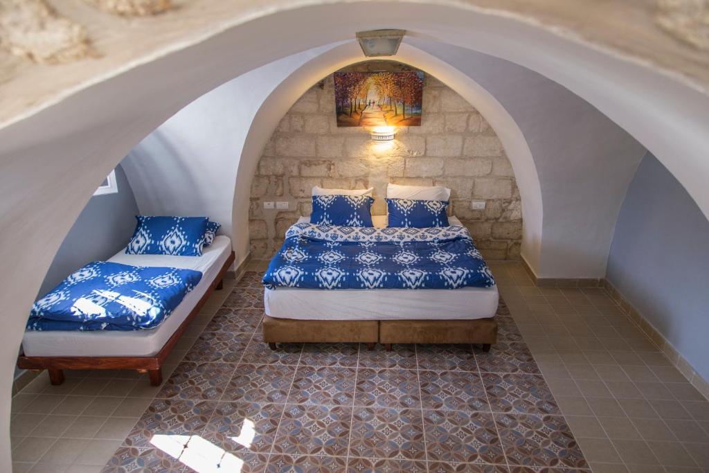 拿撒勒亚历山大旅馆的带拱门的客房内的两张床