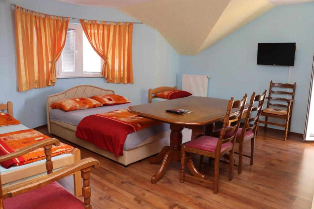 ProzorRooms & Apartment Jozić的卧室配有一张床和一张桌子及椅子