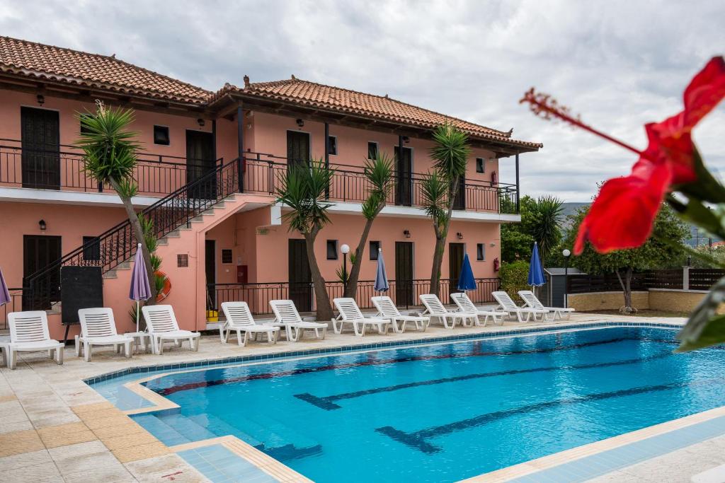 拉加纳斯Julias Apartments的一座带游泳池和椅子的酒店和一座建筑