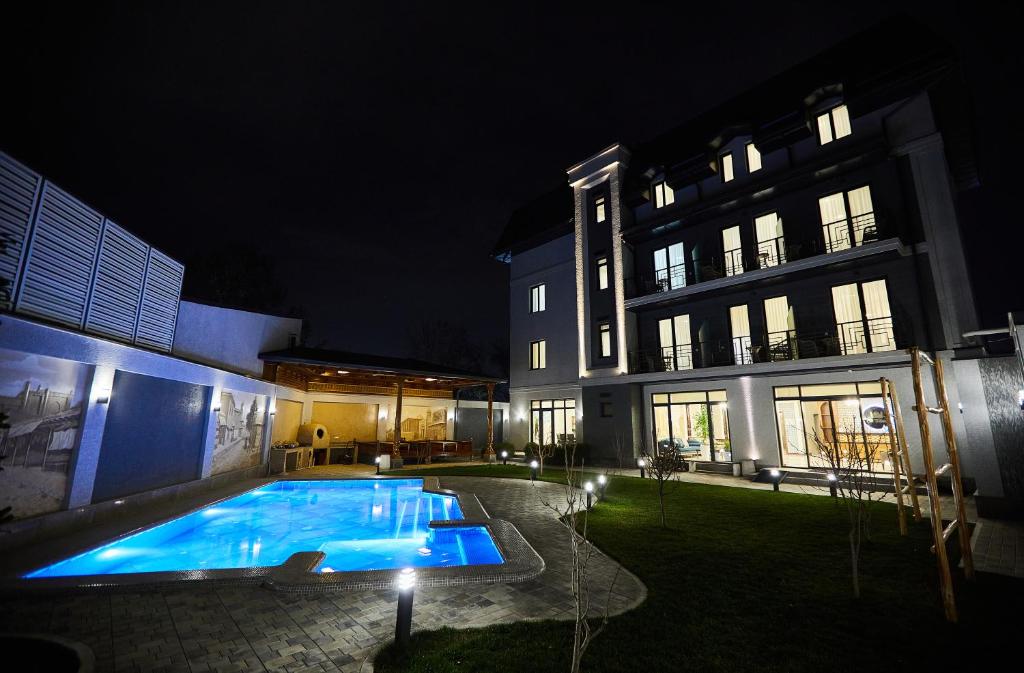 塔什干OLD TASHKENT Hotel & Spa的夜间在建筑物的院子中的一个游泳池