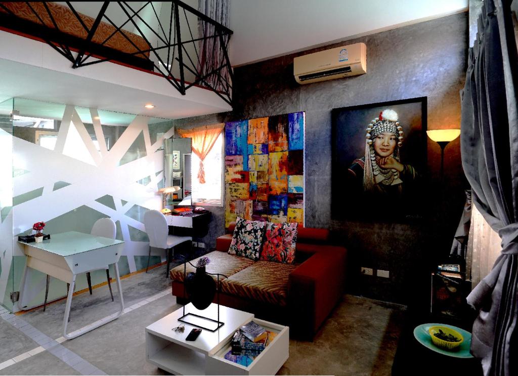 查龙普吉岛天堂旅馆的客厅配有红色的沙发和墙上的绘画