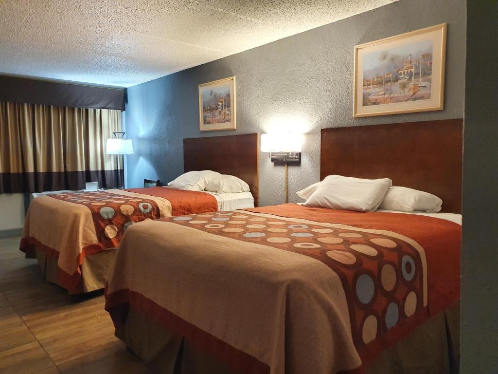 南帕诸岛South Padre Island Inn的一间带两张床和橙色床单的酒店房间