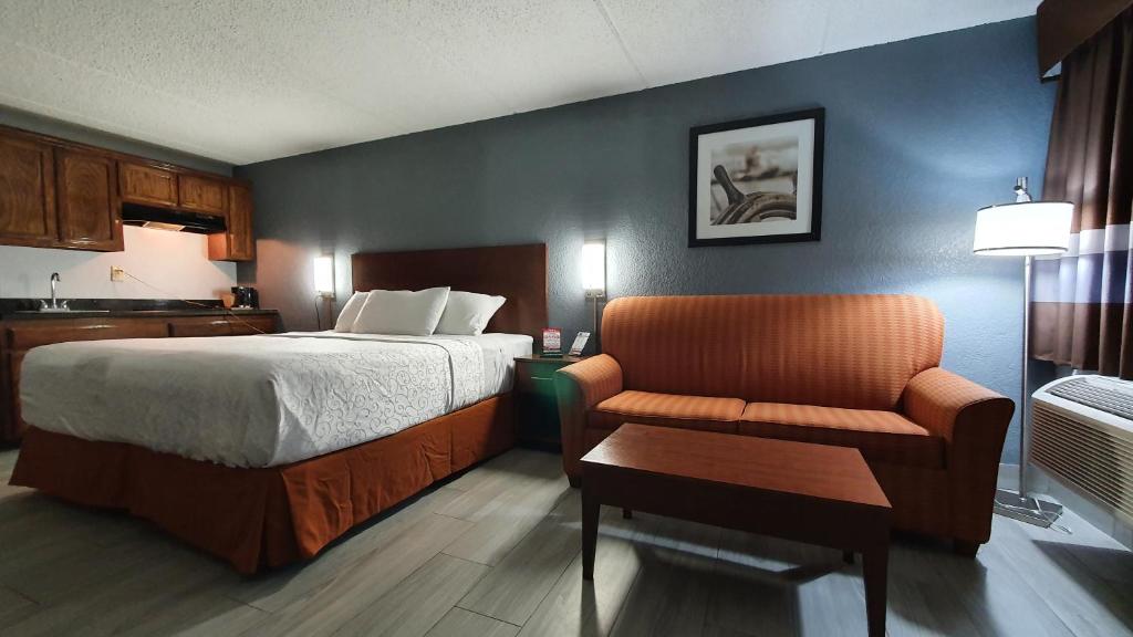 南帕诸岛South Padre Island Inn的配有一张床和一把椅子的酒店客房