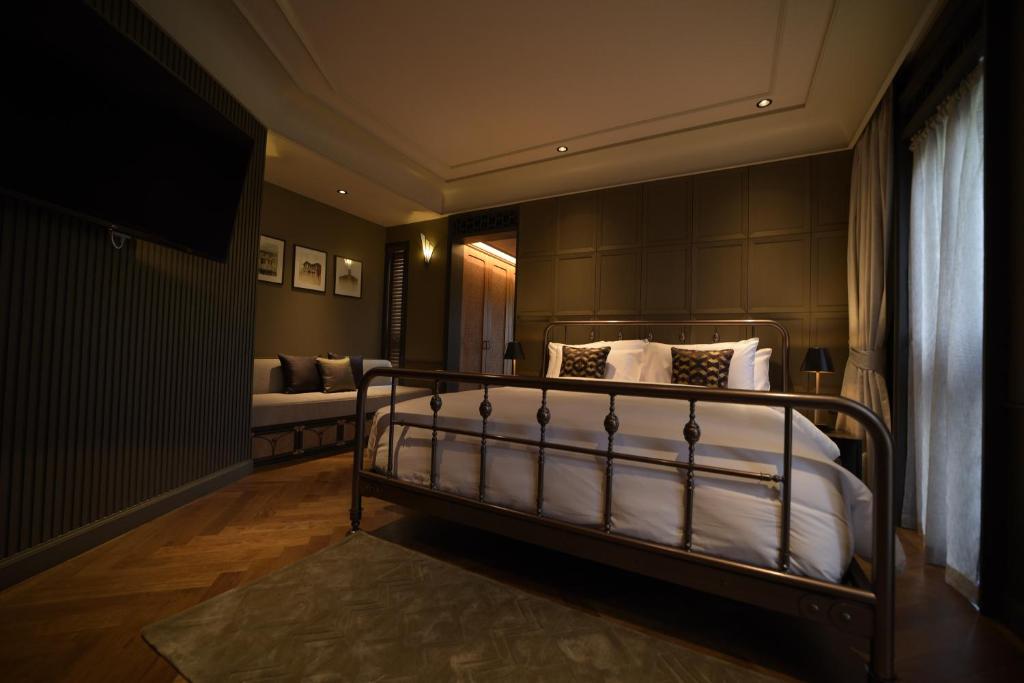 普吉镇Hotel Verdigris的一间卧室配有带白色床单和枕头的床。