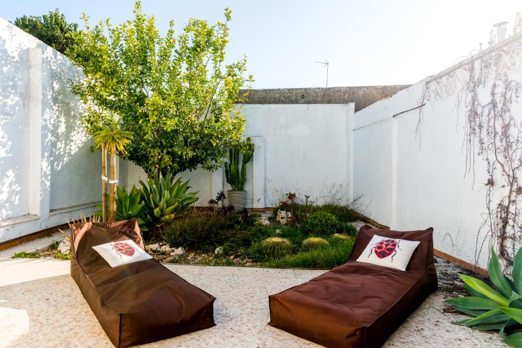 卡斯蒂列哈德拉库埃斯塔Holi-Rent La Casa del Limonero的庭院设有两把棕色椅子和围栏