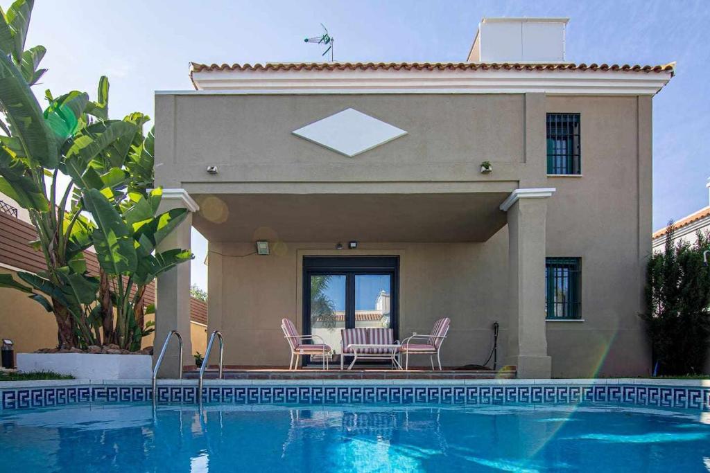 多列毛利诺斯Modern beach villa with parking and private pool的房屋前有游泳池的房子