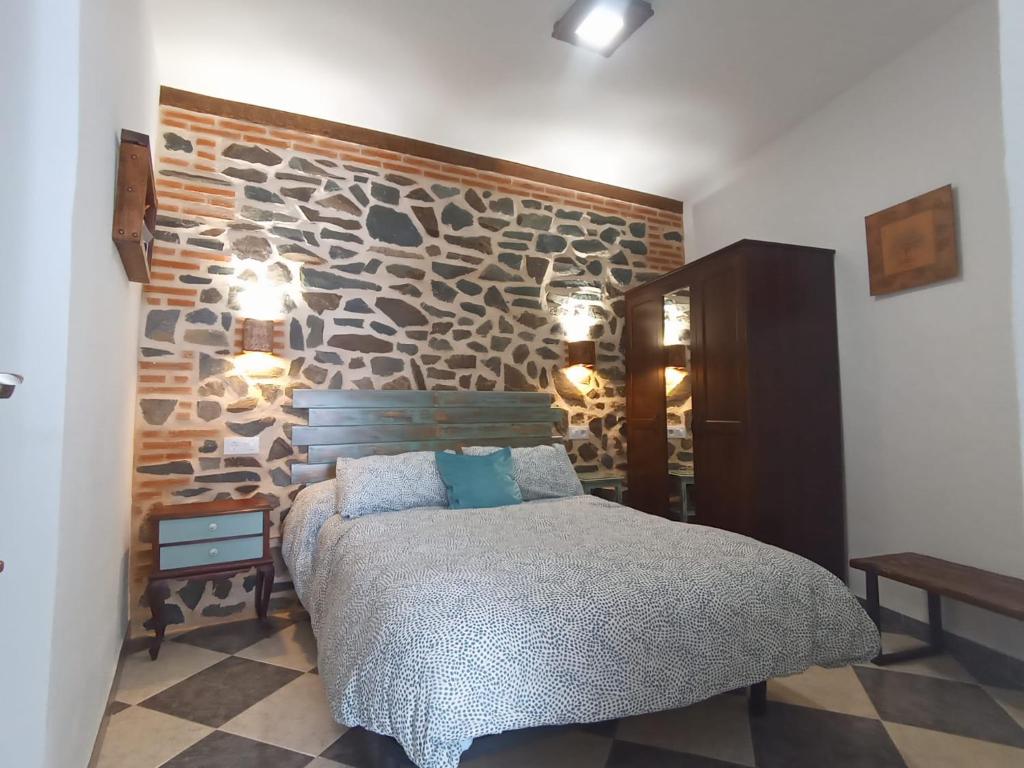 查兹拉德拉谢拉Casa Monte Los Peñasquitos的一间卧室设有石墙和床