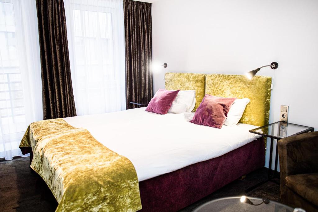考纳斯HOF HOTEL的一间卧室配有带白色床单和粉红色枕头的床。