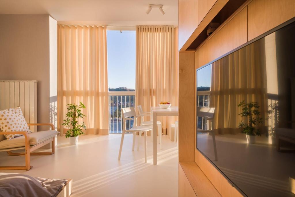 新戈里察Elegant Studio Apartment with Panoramic View的一间客厅,配有一张桌子,享有一个房间的景色