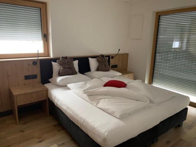 奥蒂塞伊Dependance Residence Altea的卧室内的一张带白色床单和枕头的大床