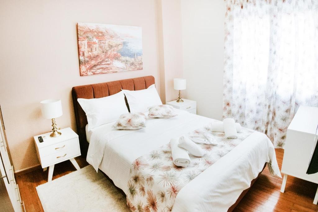 帕特雷Best House, Ellinou Stratiotou, Ayia, Patra的卧室配有白色床和毛巾