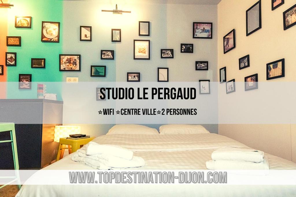 第戎STUDIO LE PERGAUD Topdestination-Dijon - Centre ville - Classé 2 étoiles的卧室配有一张床,墙上挂有图片