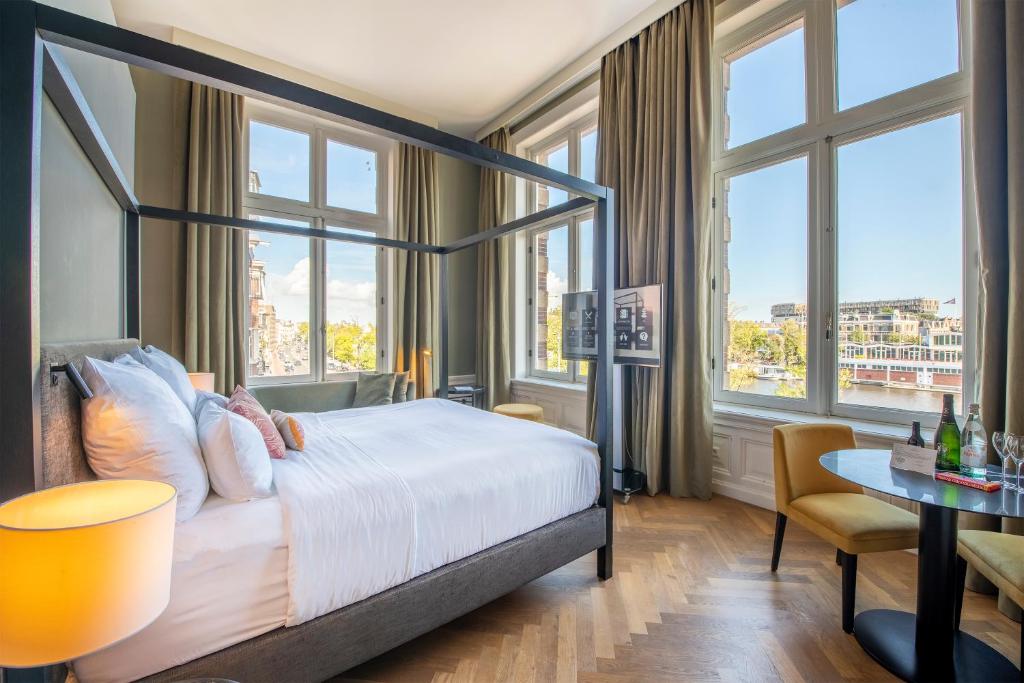 阿姆斯特丹Pestana Amsterdam Riverside的酒店客房设有一张床、一张书桌和窗户。