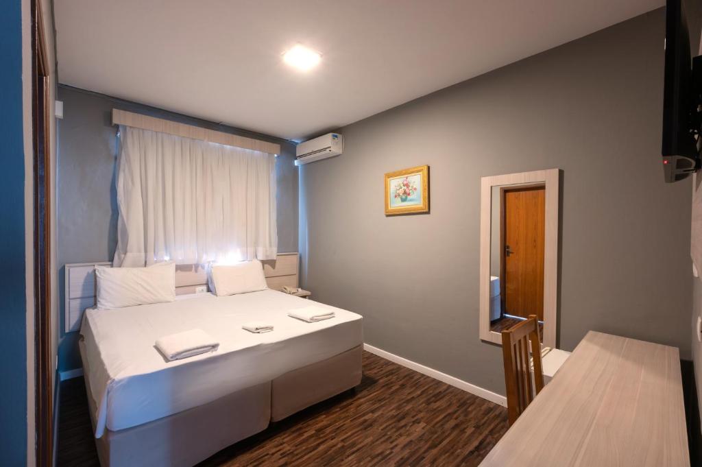 特雷斯科拉松伊斯惹得卡尔顿意大利皇宫酒店的卧室设有一张白色大床和一扇窗户。