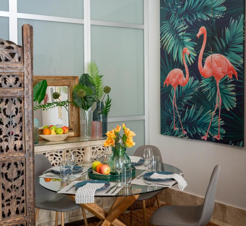 塞维利亚Apartamento Alma Sevilla的用餐室配有鸟画桌