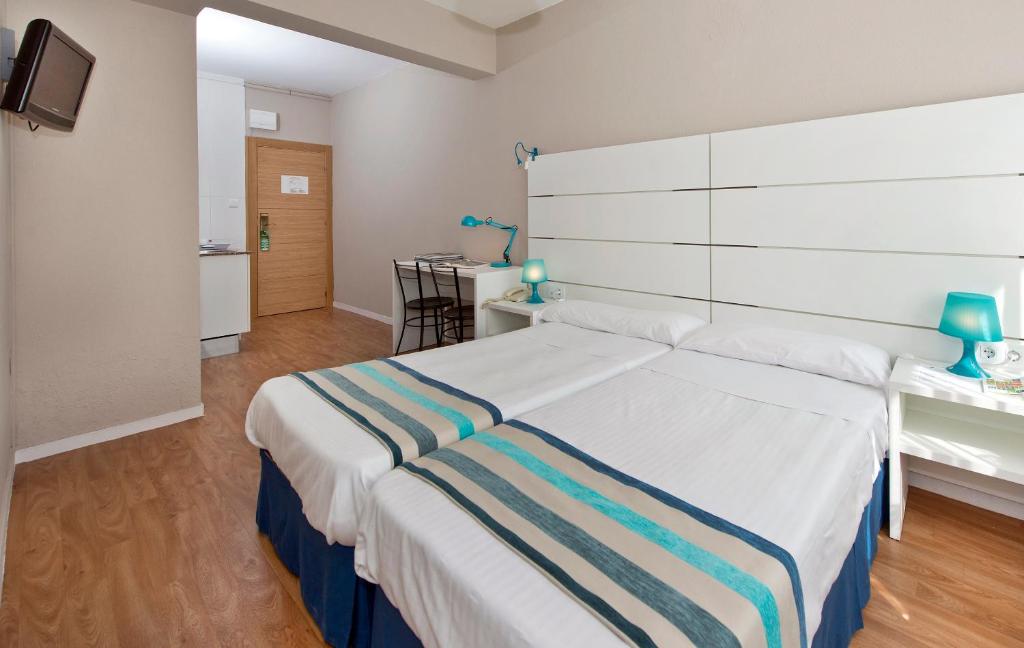 桑坦德阿兰萨苏一室公寓酒店的卧室配有一张带条纹毯子的大型白色床