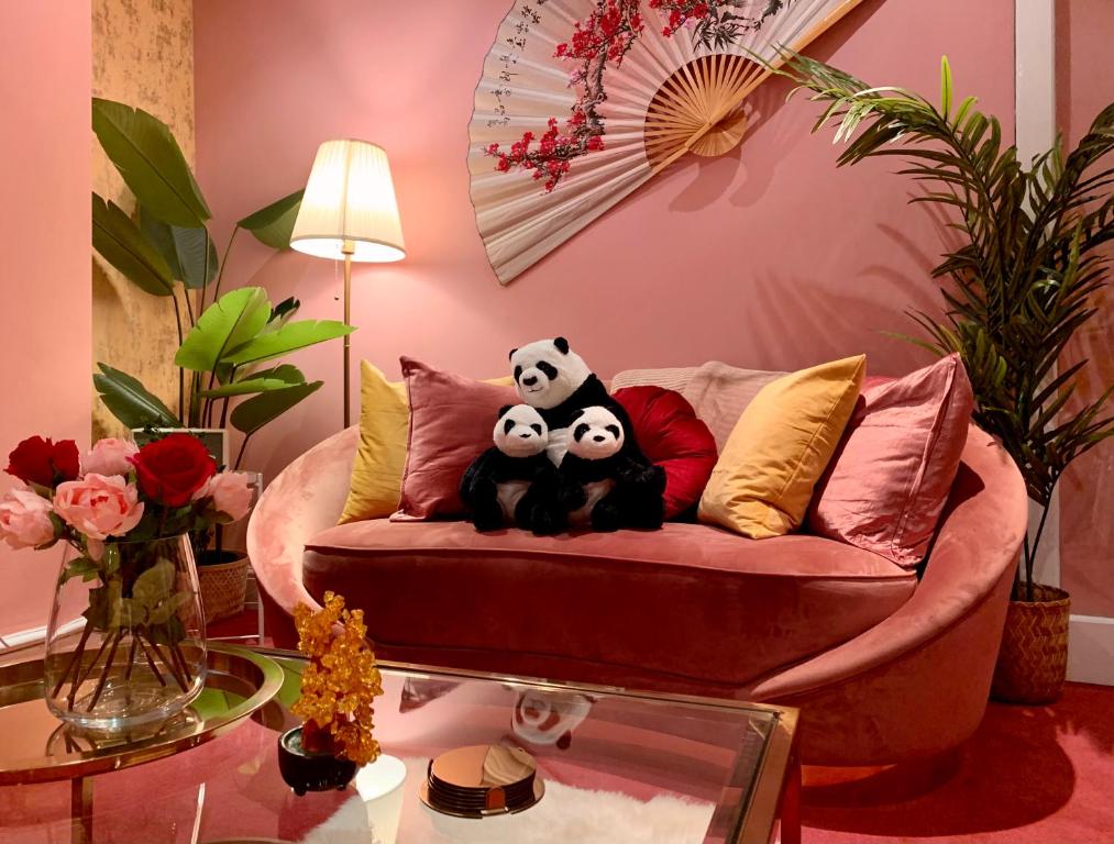 伦敦London Chinatown Apartments的客厅里沙发上的两只熊猫