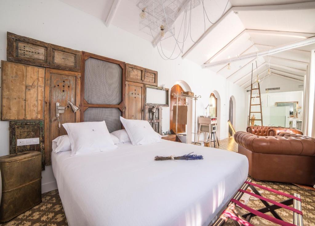 科尔多瓦玛迪娜酒店的卧室配有一张白色的大床和一张沙发。