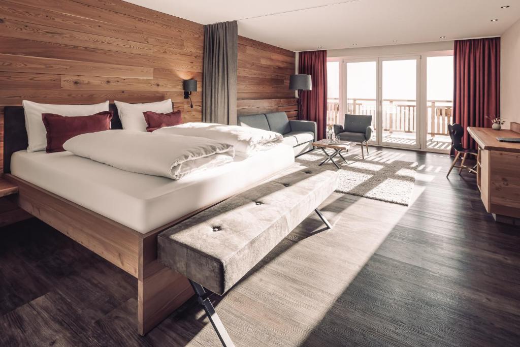 东蒂罗尔地区马特赖Naturhotel Outside的一间卧室配有一张大床和一张书桌