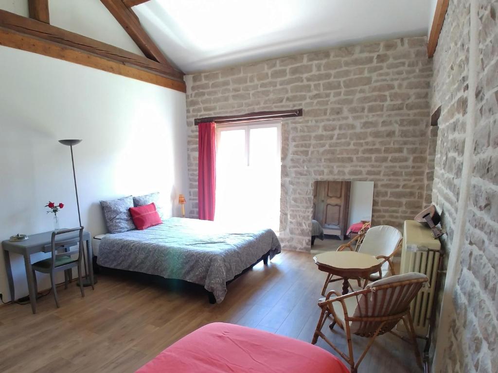 第戎2 chambres privées au calme à la Maison des Bambous的一间卧室设有一张床和砖墙
