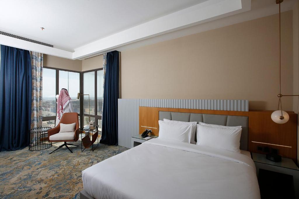 吉赞Grand Plaza Hotel - Jazan的酒店客房带一张大床和一把椅子
