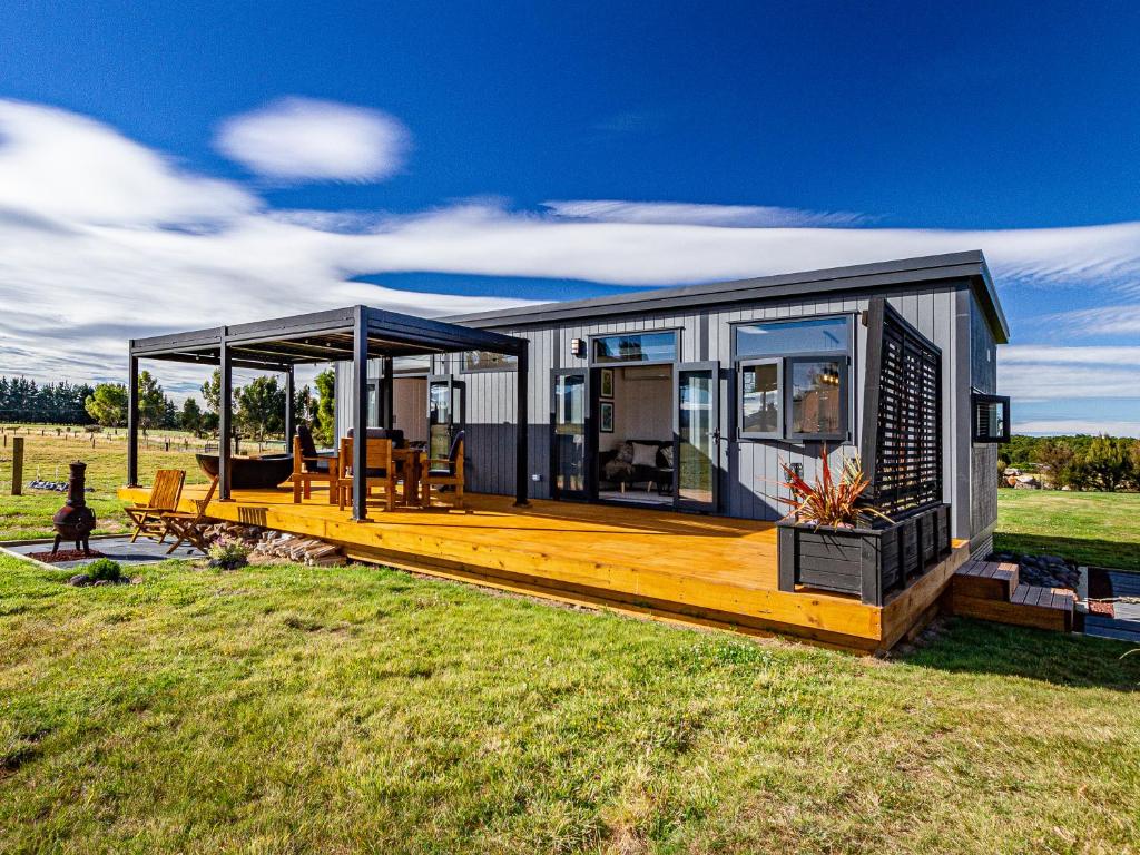 奥阿库尼Mangateitei Views - Rangataua Tiny Home的现代房屋设有大型木质甲板