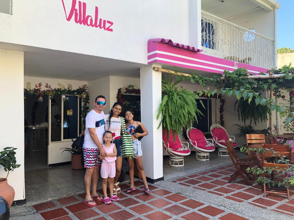 圣玛尔塔Casa Hospedaje Villaluz- a 5 minutos de la Playa的站在建筑物前的家庭
