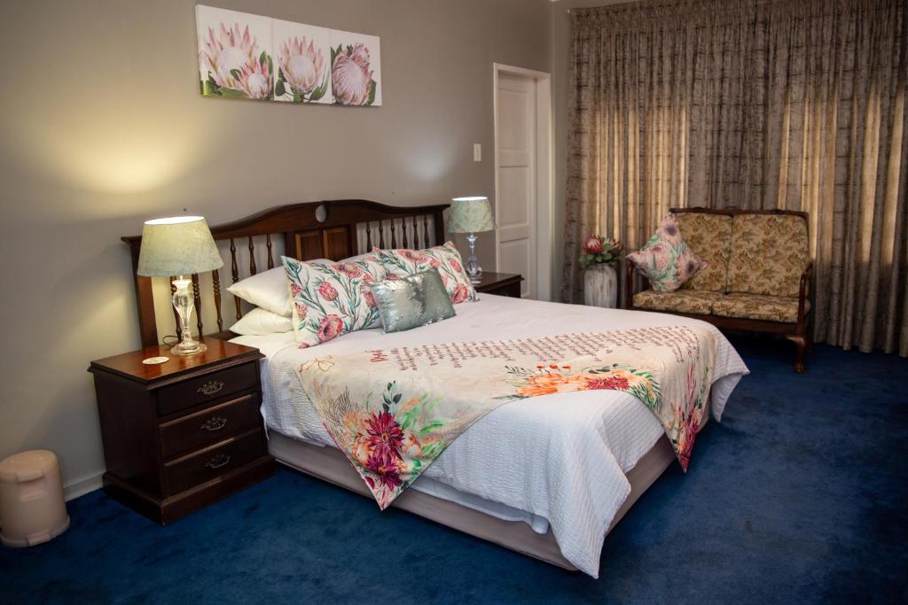 伯诺尼Ailani Blue Room的一间卧室配有一张大床和一把椅子
