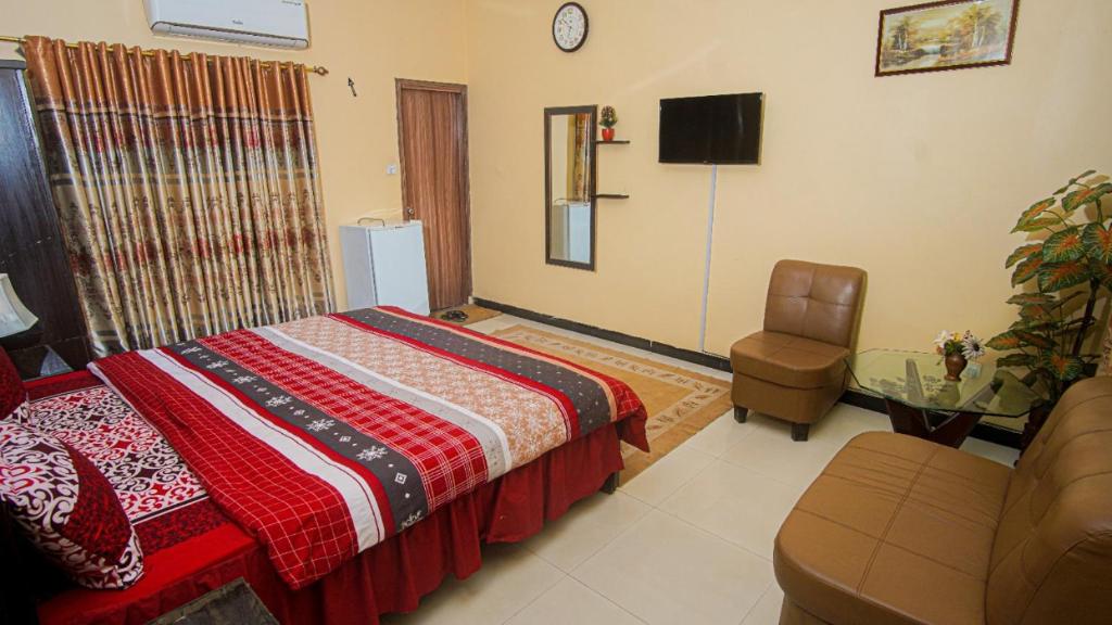 卡拉奇Seasons Inn的一间卧室配有一张床、一把椅子和一张桌子