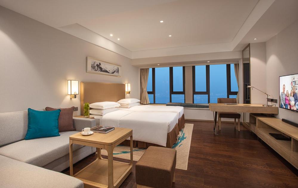 重庆重庆盛捷长江服务公寓的酒店客房,配有床和沙发