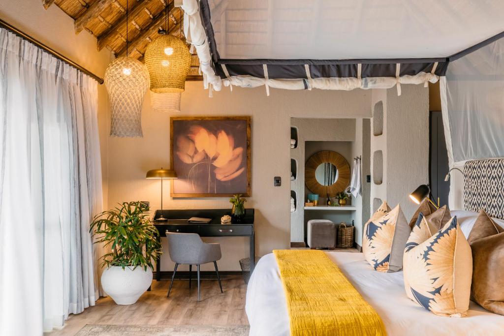 萨比沙禁猎区辛班比利荆棘山林小屋的一间卧室配有一张大床和一张书桌