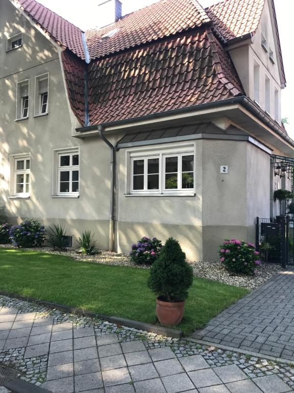 博特罗普Haus in der Gartenstadt的一座带瓦屋顶和绿色庭院的房子