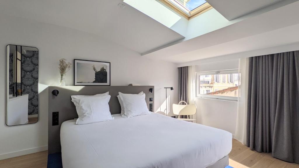 马赛Maison Juste的卧室配有一张白色大床和天窗