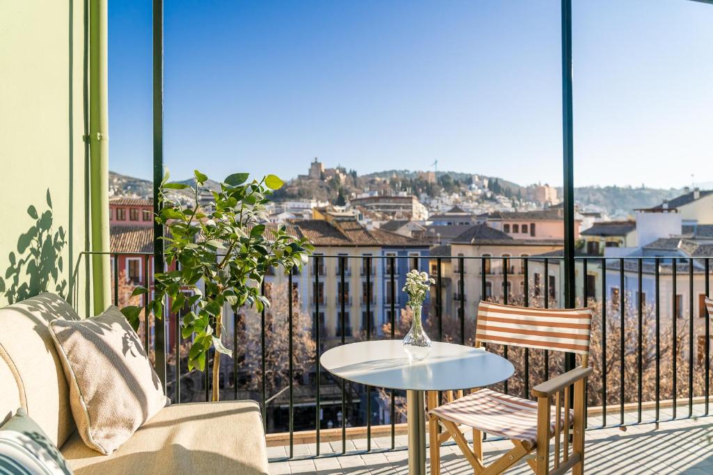 格拉纳达U-Sense Granada Centro的设有一个配有桌椅并享有美景的阳台。