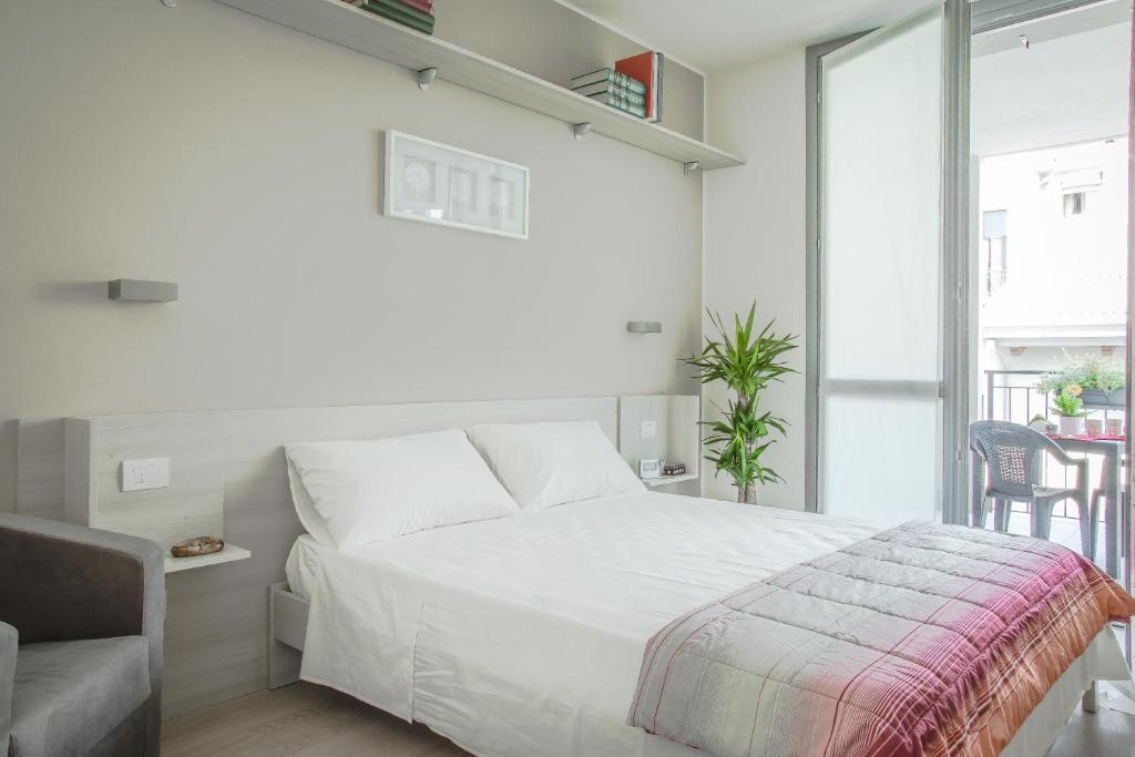 米兰阿尔法比可卡公寓 的白色卧室配有床和椅子