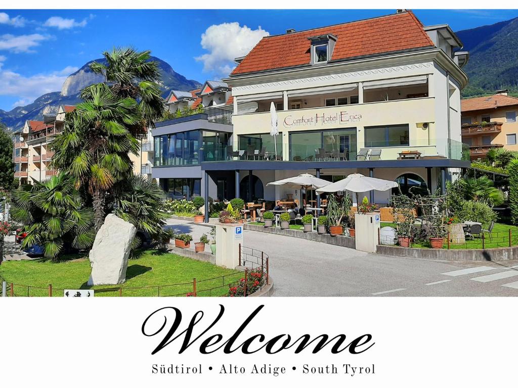 萨洛尔诺Hotel Comfort Erica Dolomiti Val d'Adige的前面有欢迎标志的建筑